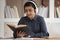 Focused indian girl in headphones studying reading book