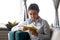 Focused Indian woman reading book, sitting on cozy sofa