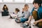 focused kids programming robots with laptops while sitting on floor stem