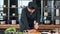 Focused male chef in uniform cutting fresh pepper on table at kitchen. Medium shot on RED camera