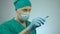 Focused male surgeon holding sharp scalpel in hand, nodding to start surgery