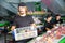 Focused male worker working at fruit warehouse carrying box with mangos