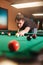 Focused man beats a billiard ball.