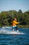 Focused man, in orange shirt and helmet, is trained in wakeboarding