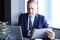 Focused mature businessman deep in thought while sitting at a table in modern office