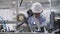 Focused mature factory technician wearing hardhat