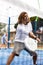 Focused middle-aged Latin man playing padel on court. View through tennis net