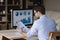 Focused millennial business man analyzing marketing reports on desktop monitor