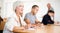 Focused motivated older woman listening to lecture in classroom