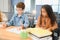 Focused multiracial students kids writing down data into notebook while sitting at table