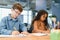 Focused multiracial students kids writing down data into notebook while sitting at table