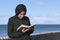 Focused muslim woman reading a book outdoors