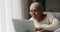 Focused older adult female pensioner learn to use modern laptop