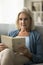 Focused older pensioner woman excited with book story reading paper