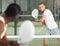 Focused padel player hitting two handed backhand in close court