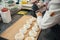 Focused pastry chef putting icing on top of meringues