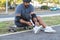 Focused person with disability tying laces in park