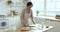 Focused pretty mature baker woman in apron rolling