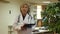 Focused professional aged female physician filling up medical forms on laptop while sitting at table in office