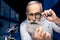 Focused scientist looking at hand through magnifying glass in laboratory