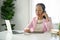 Focused senior Asian businesswoman sits at her desk, dealing business over the phone