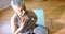 Focused senior biracial woman meditating on yoga mat at home