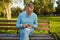 Focused senior man counting coins from his wallet while sitting on bench