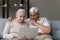 Focused serious elder couple using online app, banking service