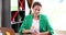 Focused serious young woman sits at table and writes down idea information in notebook