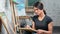 Focused skilled female painter making sketching using pencil working at art studio