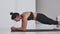 Focused sportswoman doing plank exercise at home in. Living room.