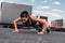 focused sportswoman doing push up on asphalt