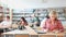 Focused teenager female student sitting at library desk, preparing for exam