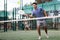 Focused teenager playing friendly paddleball match on outdoor court