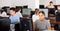 Focused teenager students sitting at desk in computer room with pc, preparing for exam. Focus on young girl