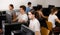 Focused teenager students sitting at desk in computer room with pc, preparing for exam. Focus on young girl