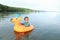 Focused toddler boy sailing inflating ring on sea