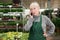 Focused woman garden shop owner having phone conversation