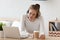 Focused woman in headset using laptop, writing notes