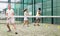 Focused woman and man learning to play padel on court