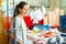 Focused woman searching for fresh seafood on icy showcase while shopping in fish store