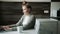 Focused woman using laptop at home in the kitchen and drinking