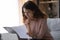 Focused woman wearing glasses reading document holding paper sheet