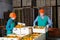 Focused women working at citrus warehouse, checking and marking tangerines in boxes