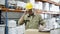 Focused worker inspecting cardboard boxes, fixing helmet.