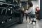 Focused worker removing contaminants from surface of car