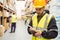Focused worker wearing yellow vest using handheld
