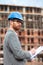 Focused young architect or civil engineer signing documents on construction site