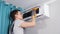 Focused young handyman cleans dust with orange cloth