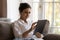 Focused young Indian tablet user woman relaxing on sofa